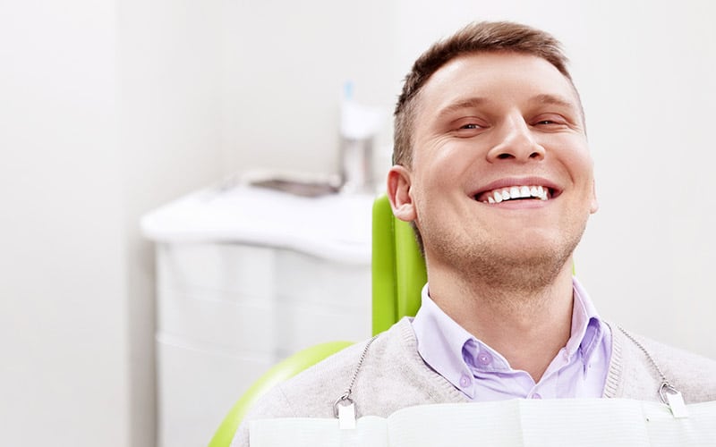 man in dental chair smiling